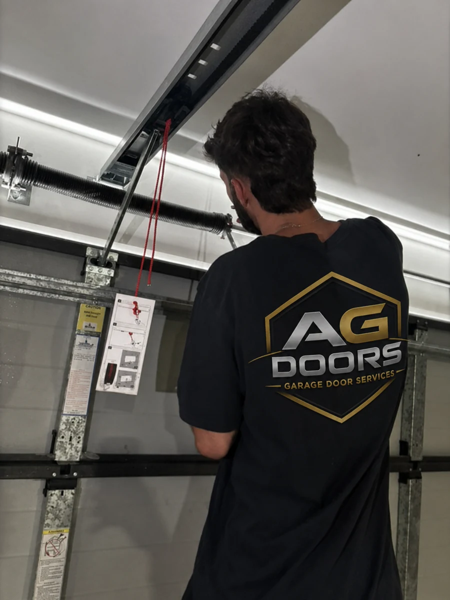 AG Doors technician checking a garage door spring and track